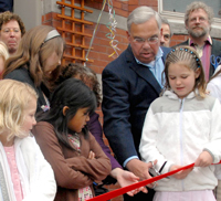 Mayor Menino, assisted by Charlie Doe's grandchildren, cuts ribbon for Doe House